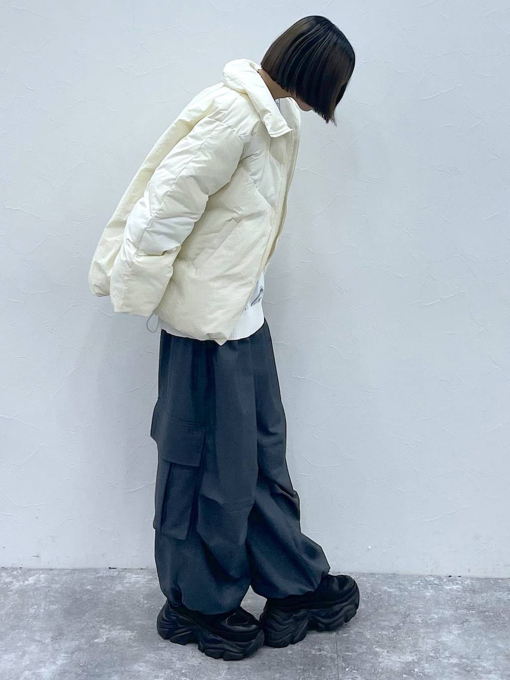 ブラック系のスニーカー、グレー系のカーゴパンツ、ホワイト系のブルゾンを着用したレディースの秋コーディネートの4枚目の写真