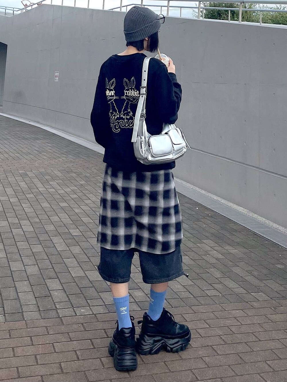 ブラック系のスニーカー、ブラック系のシャツ/ブラウス、ブラック系のデニムパンツを着用したレディースの秋コーディネートの4枚目の写真