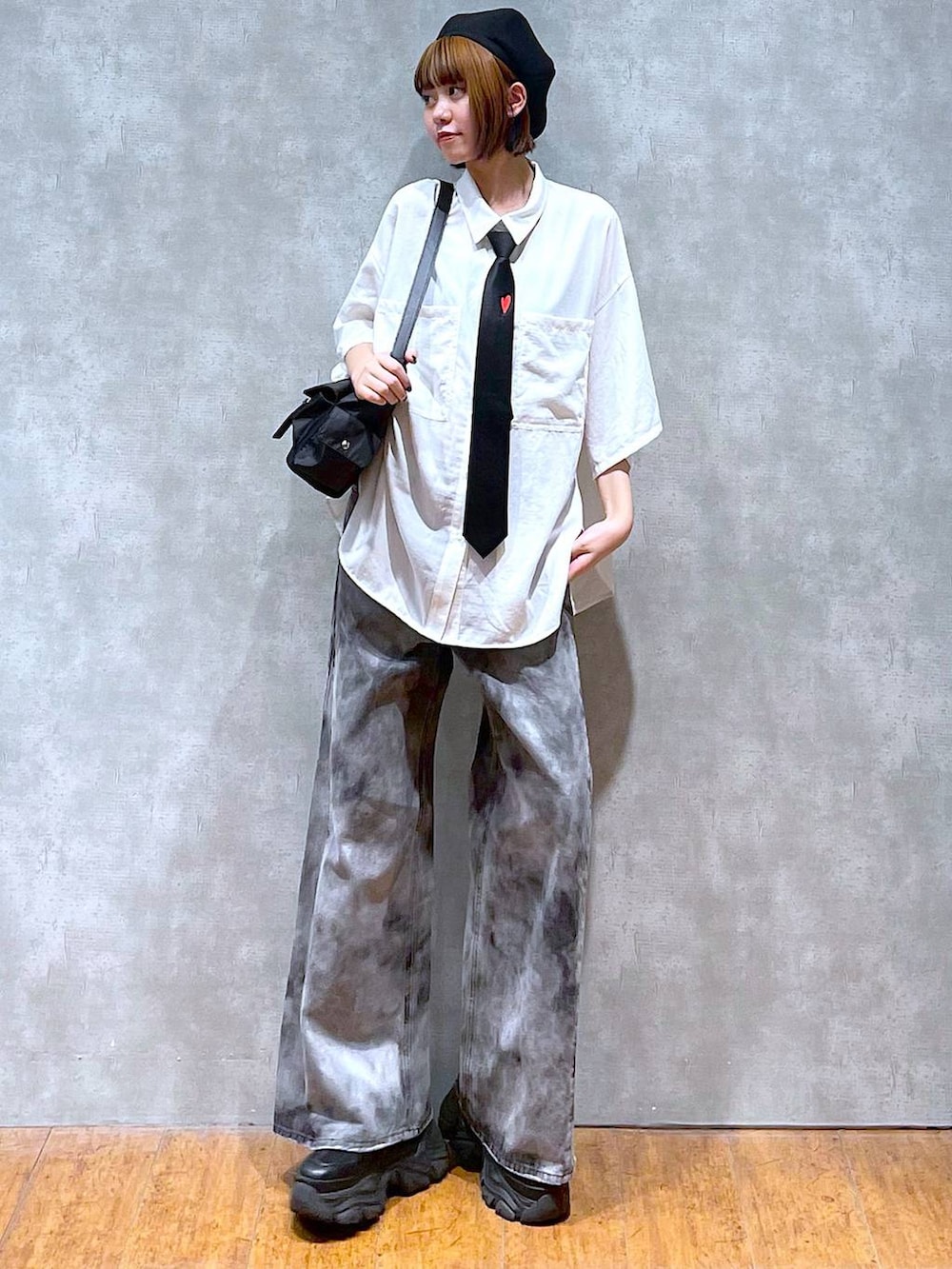 ブラック系のショルダーバッグ、ブラック系のデニムパンツ、ブラック系のスニーカーを着用したレディースの夏コーディネートの3枚目の写真