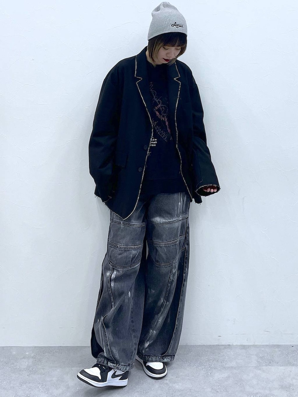 ブラック系のテーラードジャケット、ブラック系のデニムパンツ、ブラック系のスウェットを着用したレディースの冬コーディネートの2枚目の写真