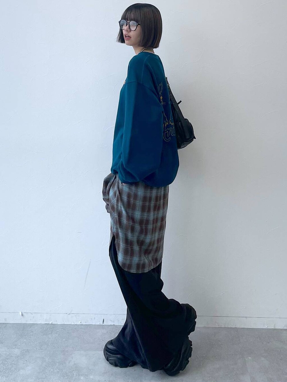 ブラック系のスニーカー、ブラック系のショルダーバッグ、グリーン系のスウェットを着用したレディースの秋コーディネートの4枚目の写真