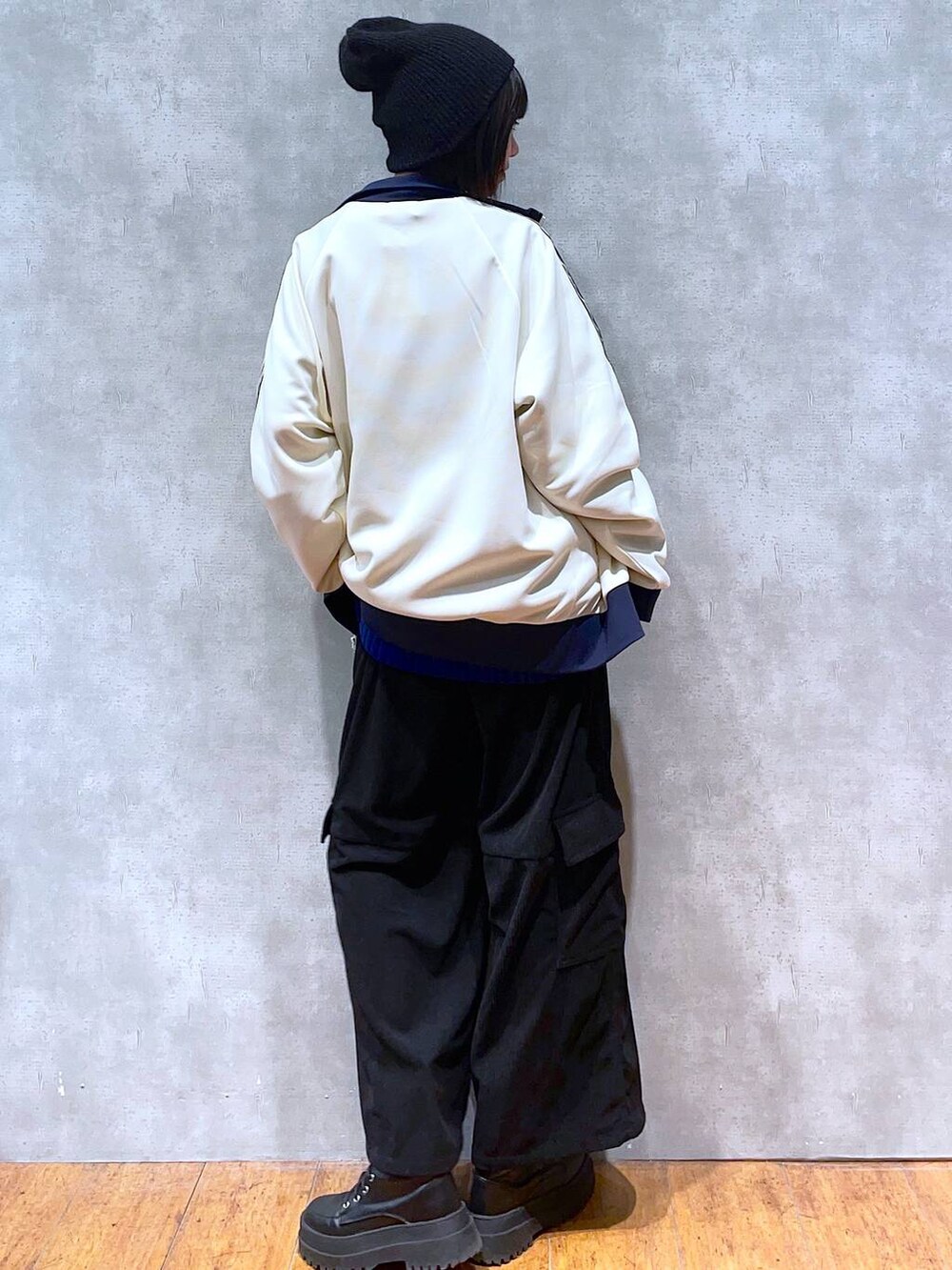 ブラック系のブーツ、ホワイト系のセットアップ、ブラック系のカーゴパンツを着用したレディースの冬コーディネートの2枚目の写真