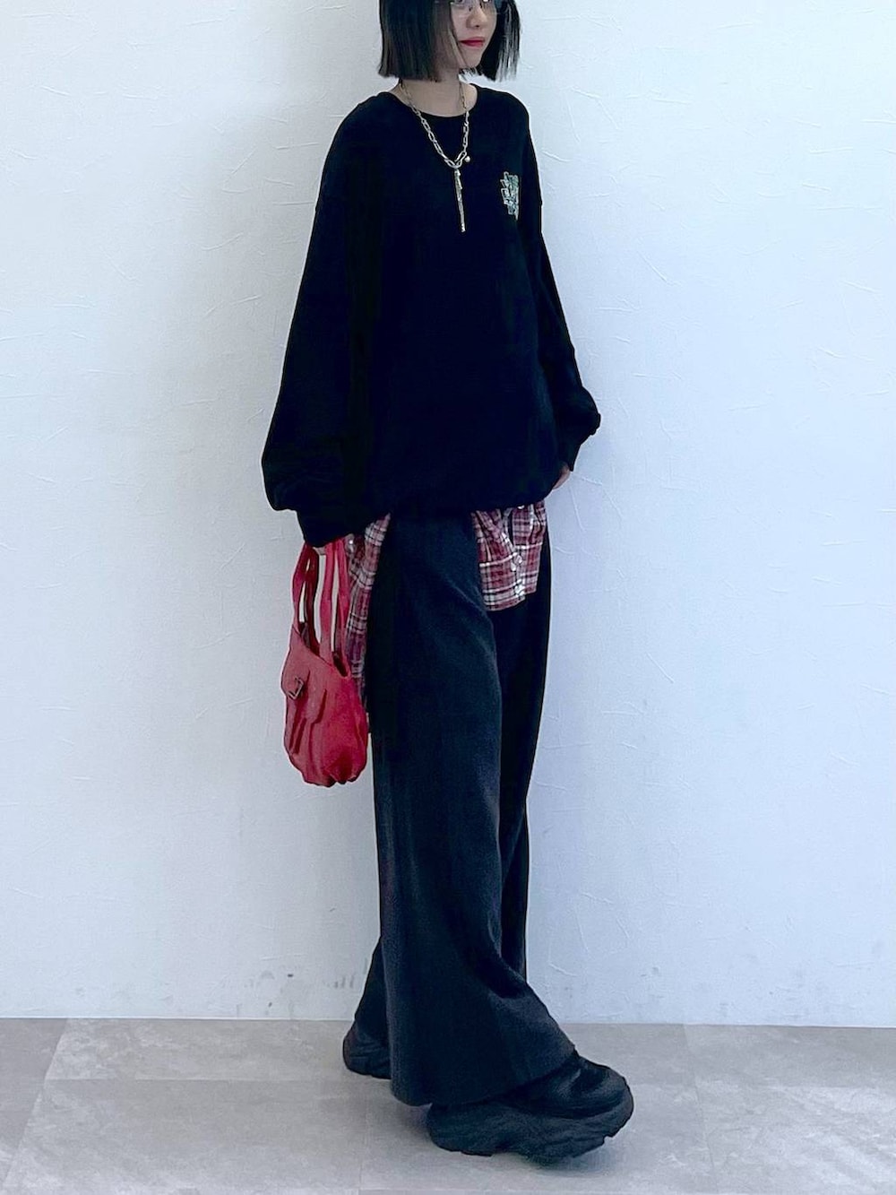 ブラック系のスニーカー、レッド系のシャツ/ブラウス、レッド系のハンドバッグを着用したレディースの秋コーディネートの4枚目の写真