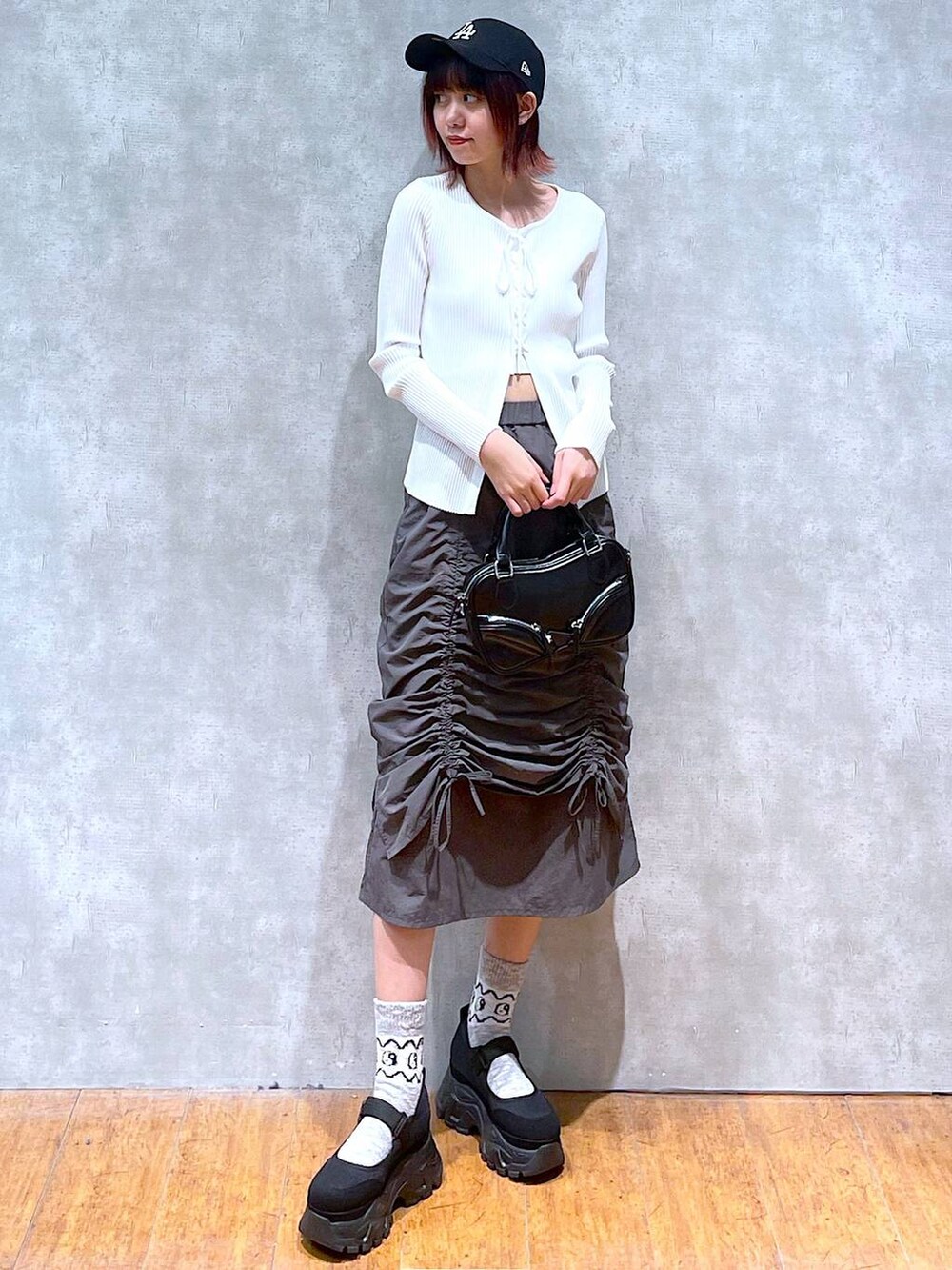 ホワイト系のニット/セーター、ホワイト系のキャミソール、ブラック系のボストンバッグを着用したレディースの春コーディネートの2枚目の写真