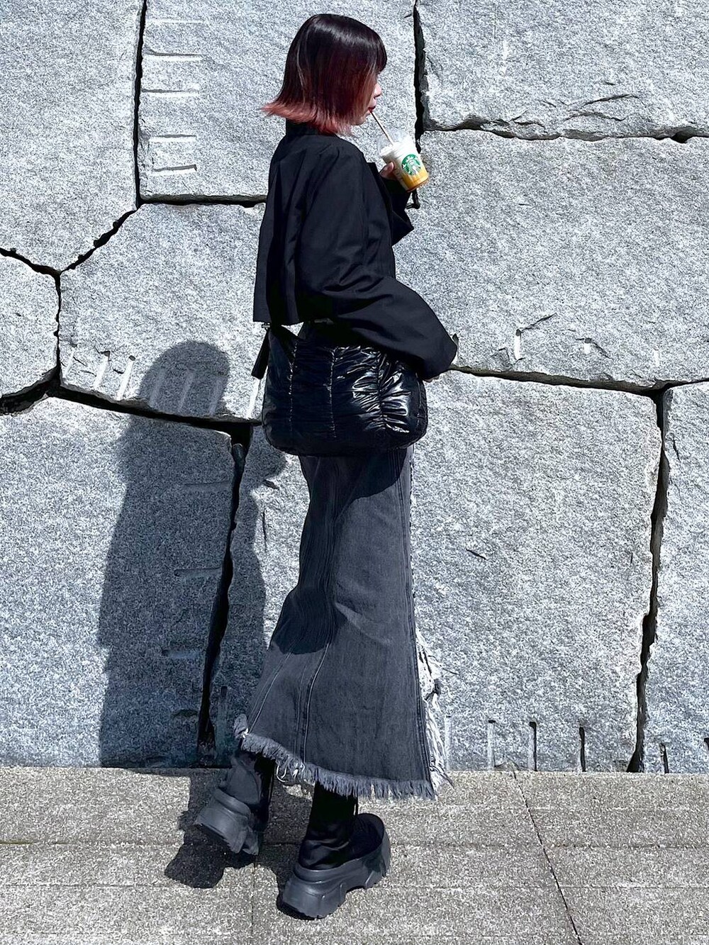 ブラック系のショルダーバッグ、ブラック系のブーツ、ブラック系のデニムスカートを着用したレディースの春コーディネートの6枚目の写真