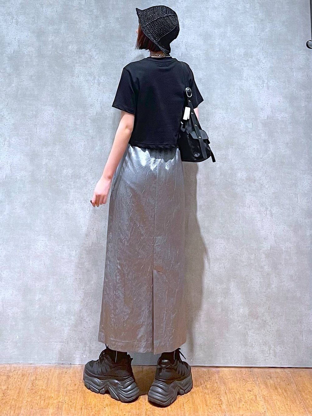 ブラック系のショルダーバッグ、ブラック系のスニーカー、ブルー系のスカートを着用したレディースの夏コーディネートの6枚目の写真