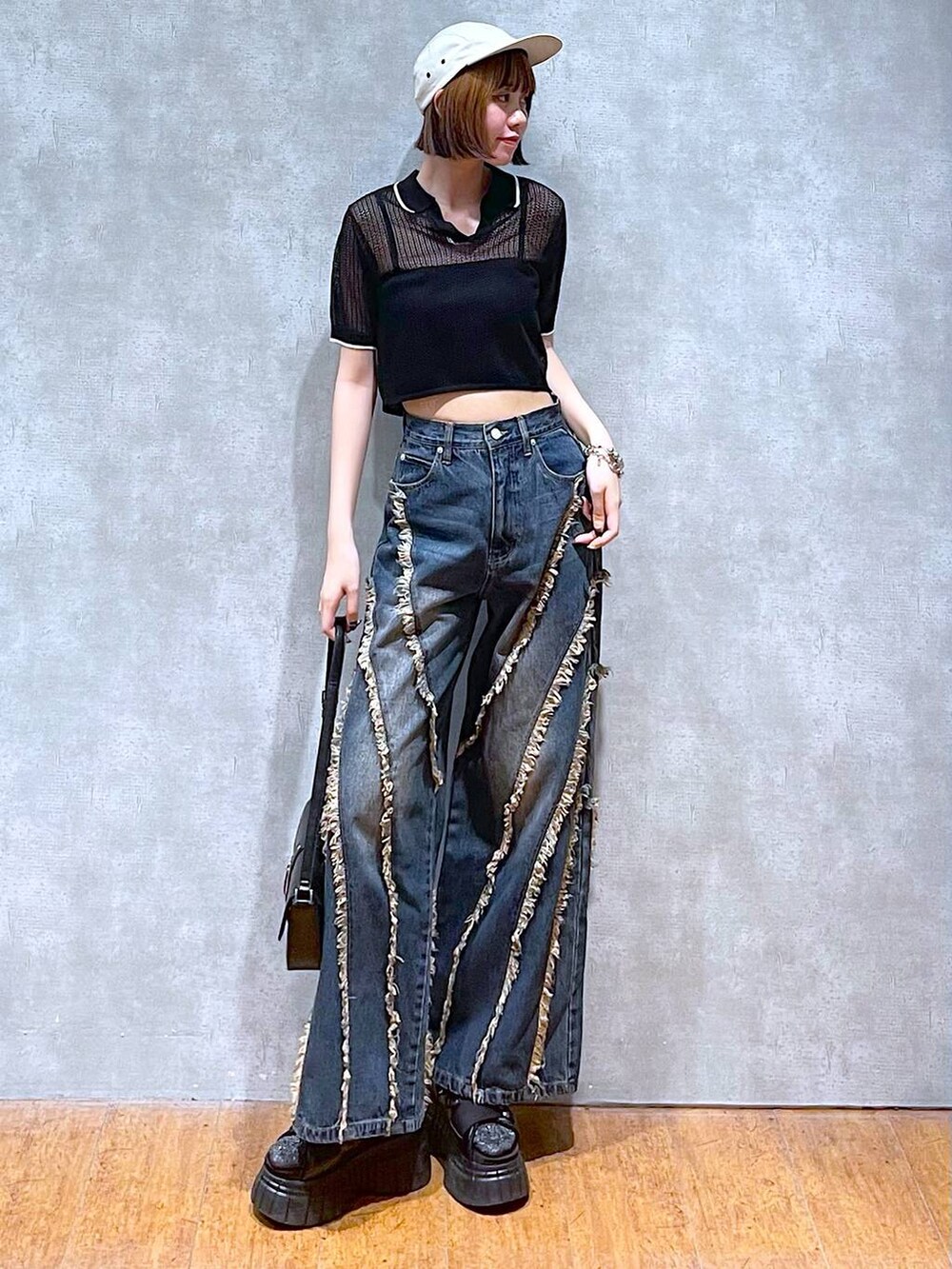 ブラック系のスニーカー、ブラック系のキャミソール、ブラック系のハンドバッグを着用したレディースの夏コーディネートの3枚目の写真