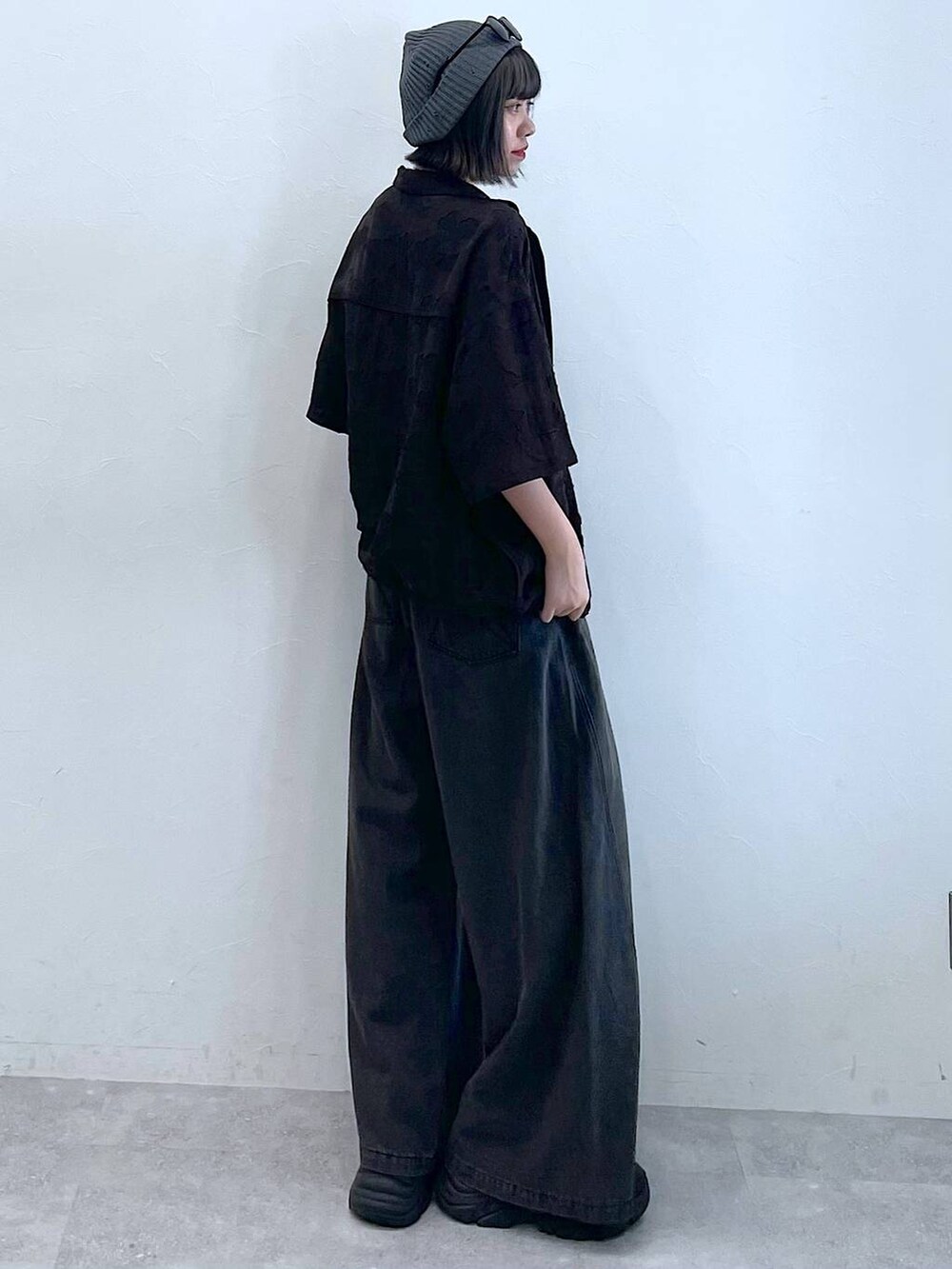 ブラック系のスニーカー、ブラック系のデニムパンツ、グレー系のシャツ/ブラウスを着用したレディースの夏コーディネートの4枚目の写真