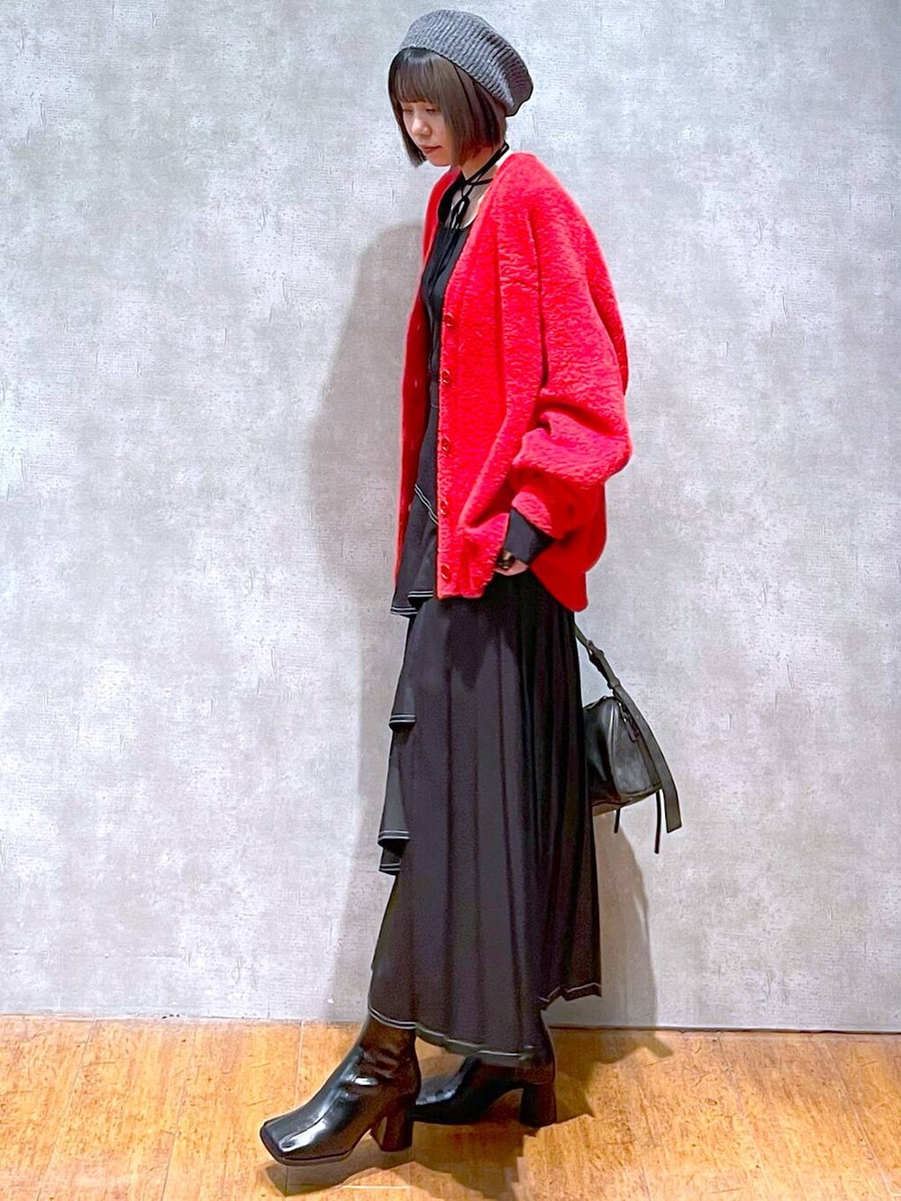 ブラック系のショルダーバッグ、ブラック系のブーツ、ブラック系のスカートを着用したレディースの秋コーディネートの5枚目の写真