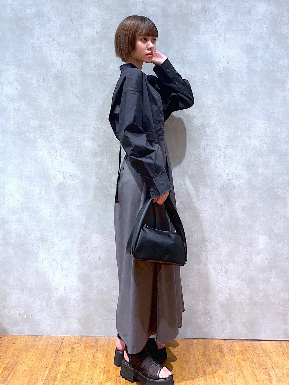 ブラック系のハンドバッグ、ブラック系のサンダル、ブラック系のシャツ/ブラウスを着用したレディースの夏コーディネートの3枚目の写真