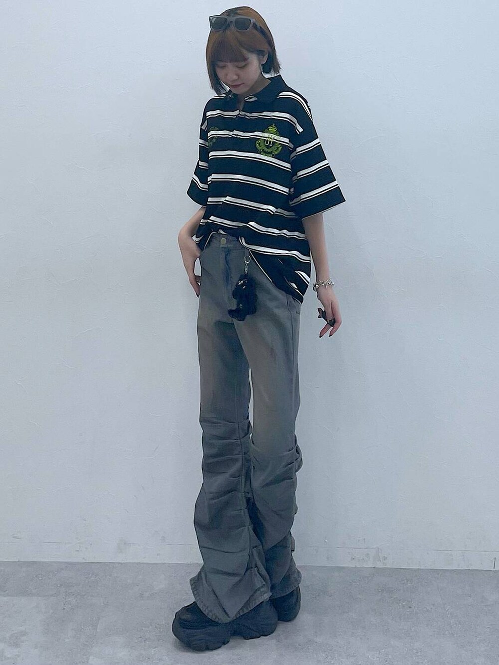 ブラック系のスニーカー、ブラック系のTシャツ/カットソー、ブルー系のデニムパンツを着用したレディースの夏コーディネートの4枚目の写真