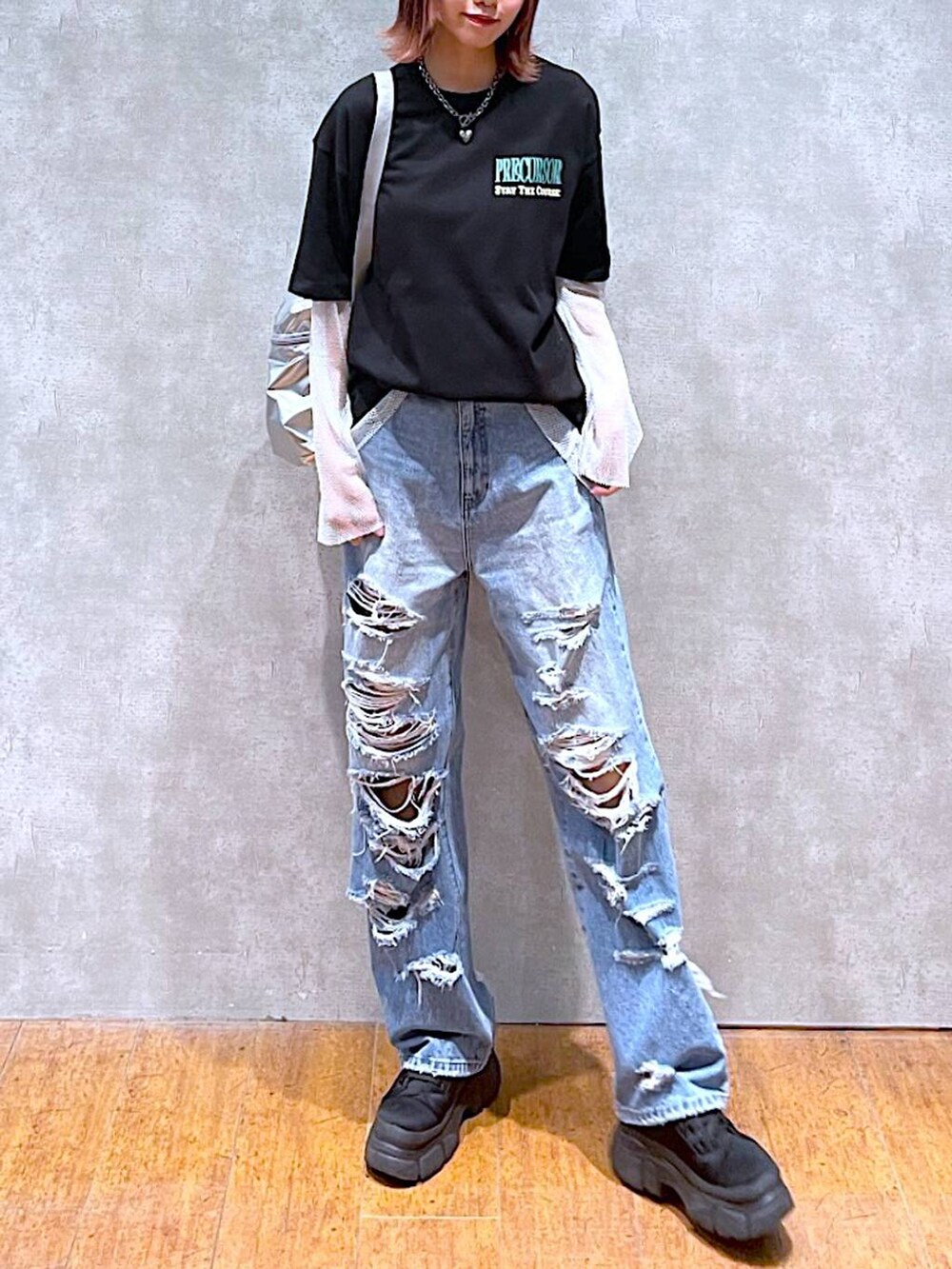 シルバー系のショルダーバッグ、ブラック系のTシャツ/カットソー、ブルー系のデニムパンツを着用したレディースの春コーディネートの3枚目の写真