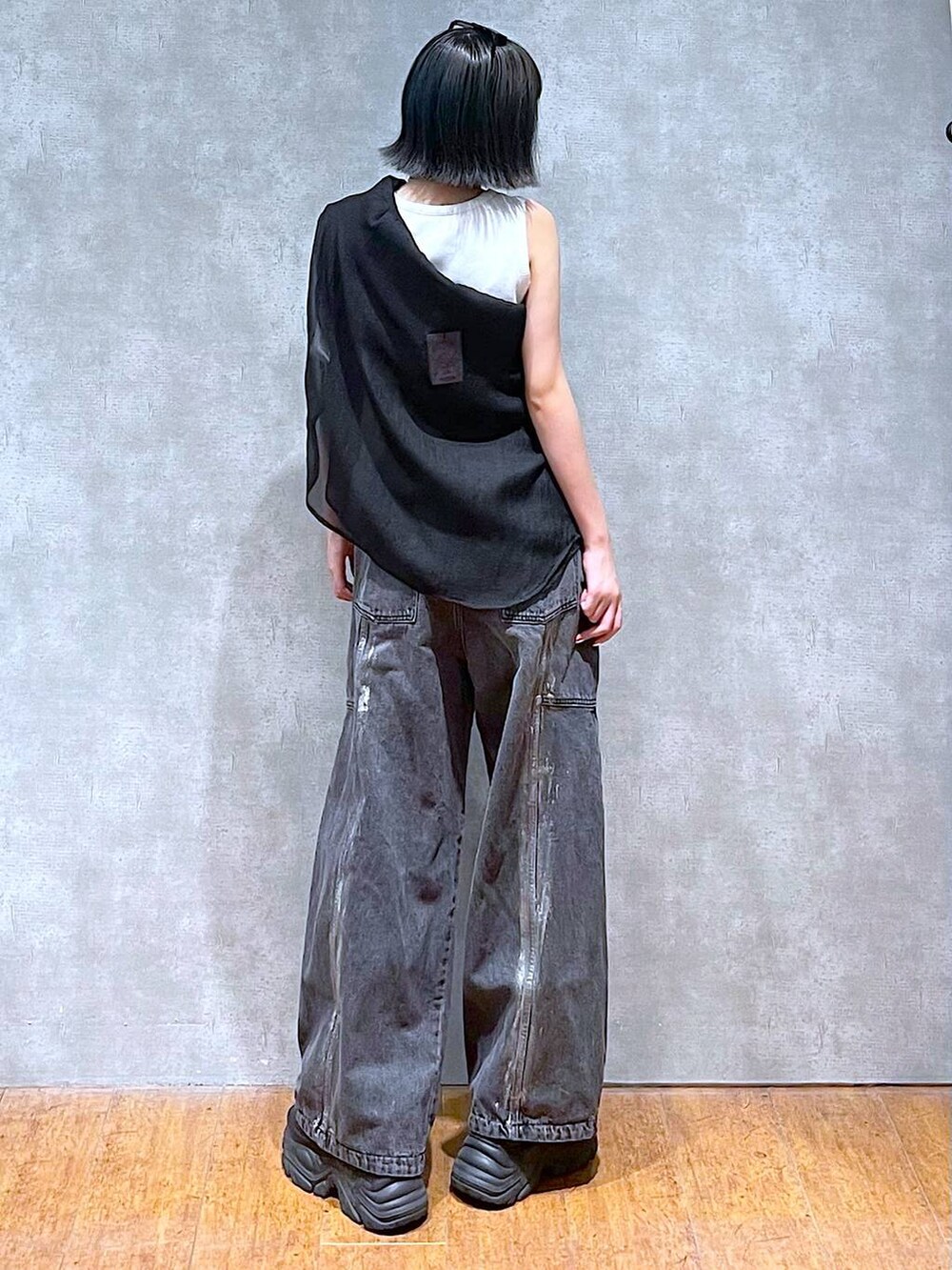 ブラック系のスニーカー、ホワイト系のタンクトップ、ブラック系のデニムパンツを着用したレディースの夏コーディネートの6枚目の写真