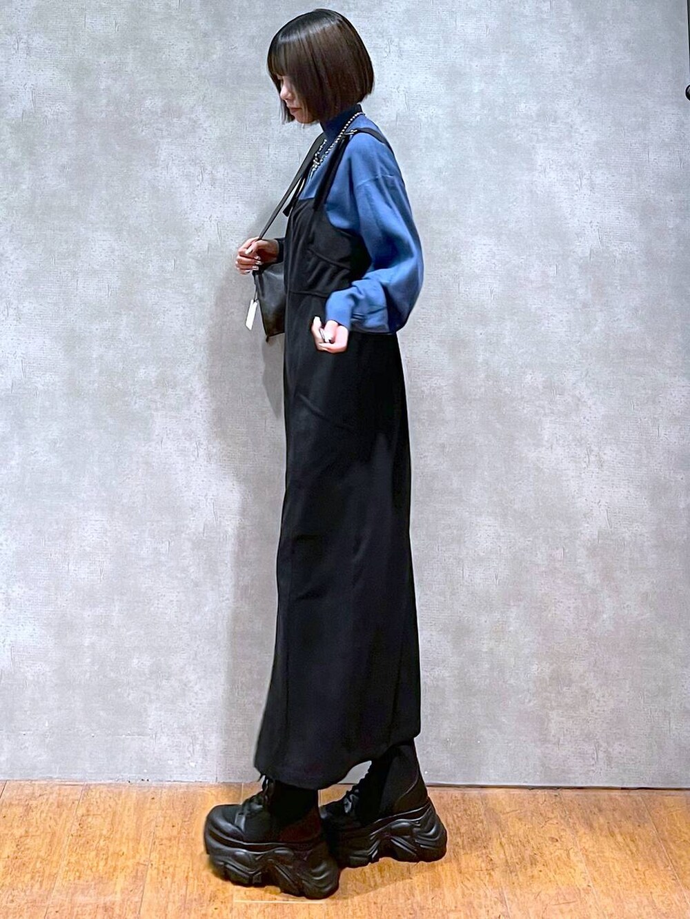 ブラック系のショルダーバッグ、ブラック系のブーツ、ブルー系のニット/セーターを着用したレディースの秋コーディネートの7枚目の写真