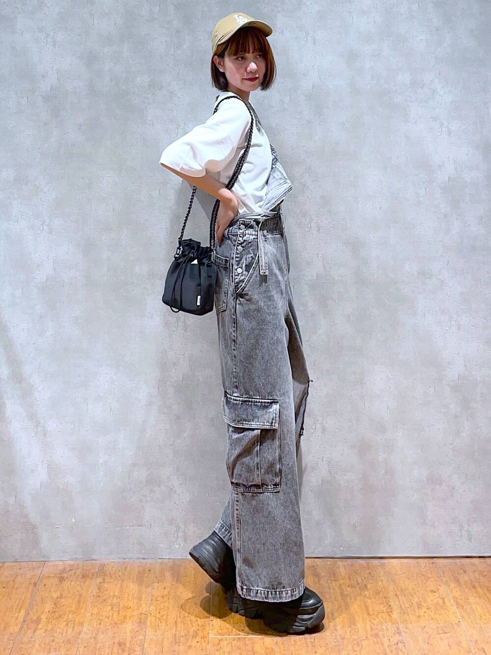 ブラック系のスニーカー、ブラック系のショルダーバッグ、ホワイト系のTシャツ/カットソーを着用したレディースの夏コーディネートの4枚目の写真