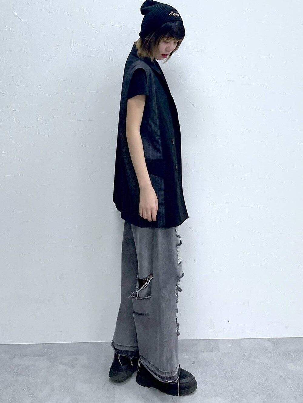 ブラック系のデニムパンツ、ブラック系のTシャツ/カットソー、ブラック系のブーツを着用したレディースの冬コーディネートの3枚目の写真