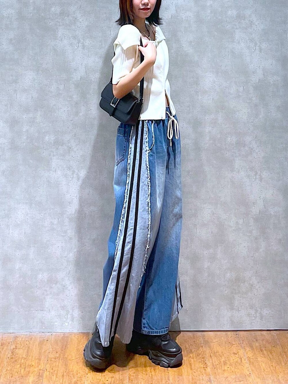 ブラック系のスニーカー、ホワイト系のニット/セーター、ホワイト系のキャミソールを着用したレディースの夏コーディネートの4枚目の写真