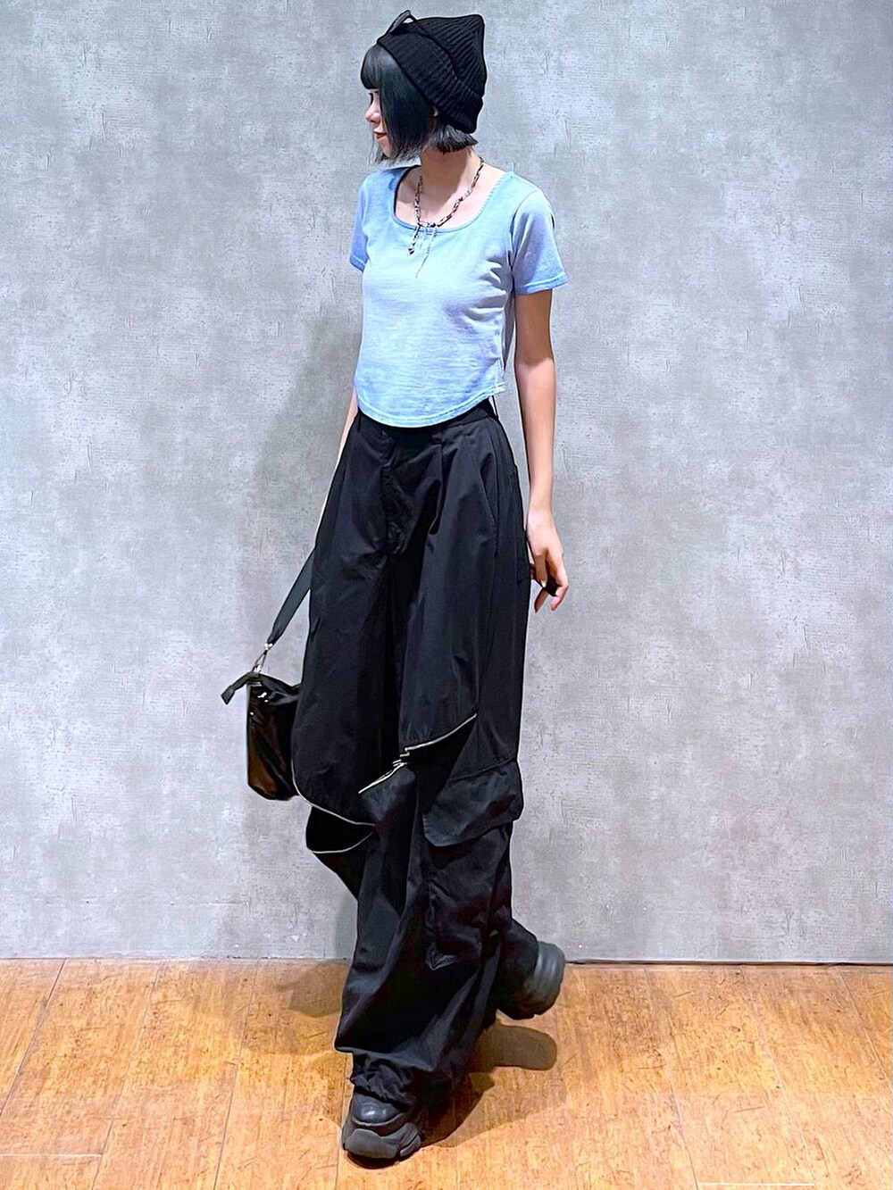 ブラック系のスニーカー、ブラック系のカーゴパンツ、ブルー系のTシャツ/カットソーを着用したレディースの夏コーディネートの3枚目の写真