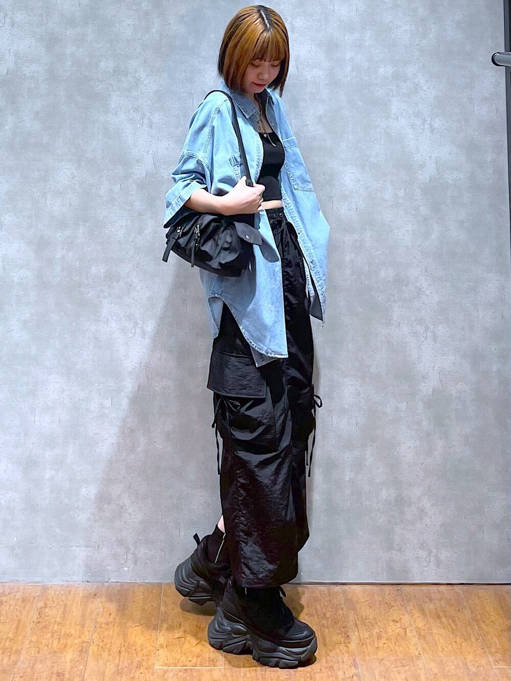 ブラック系のショルダーバッグ、ブラック系のスニーカー、ブラック系のキャミソールを着用したレディースの夏コーディネートの3枚目の写真