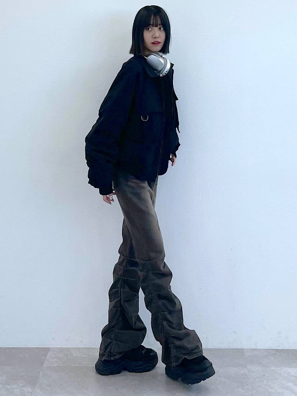 ブラック系のスニーカー、ブラック系のデニムパンツ、グレー系のTシャツ/カットソーを着用したレディースの秋コーディネートの4枚目の写真