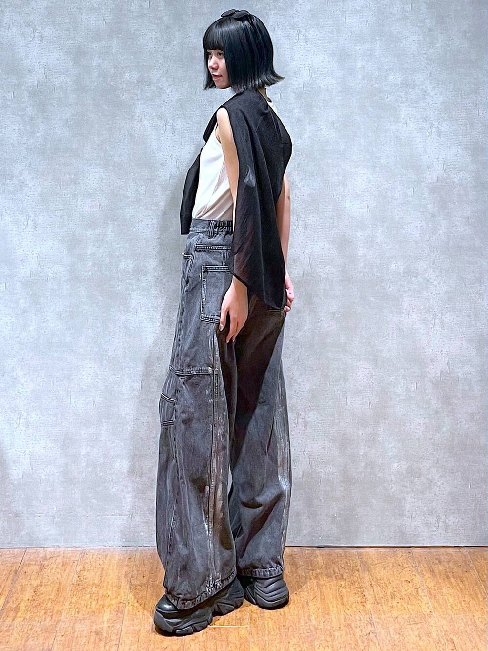 ブラック系のスニーカー、ホワイト系のタンクトップ、ブラック系のデニムパンツを着用したレディースの夏コーディネートの7枚目の写真