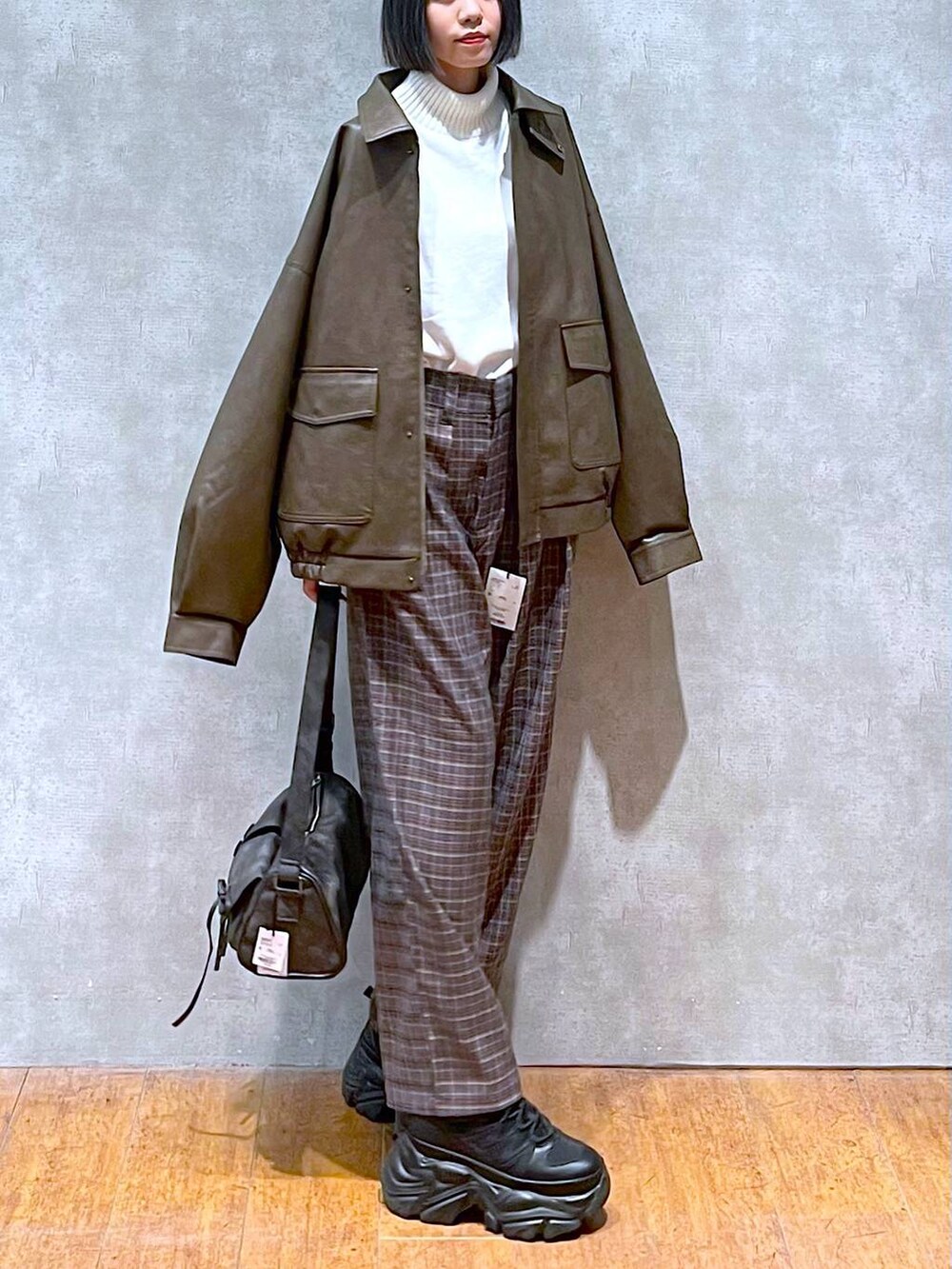 ブラック系のスニーカー、ブラック系のショルダーバッグ、ブラウン系のブルゾンを着用したレディースの秋コーディネートの8枚目の写真