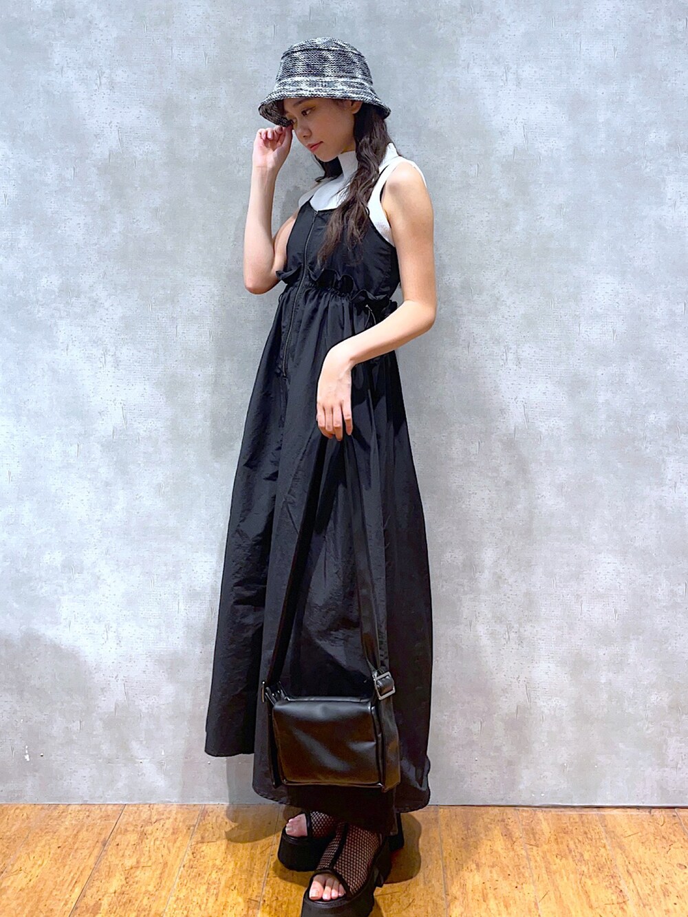 ブラック系のショルダーバッグ、ブラック系のワンピース、ホワイト系のTシャツ/カットソーを着用したレディースの夏コーディネートの2枚目の写真