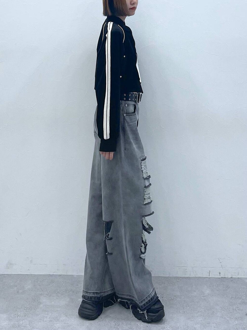 ブラック系のデニムパンツ、ブラック系のスニーカー、ホワイト系のTシャツ/カットソーを着用したレディースの夏コーディネートの6枚目の写真