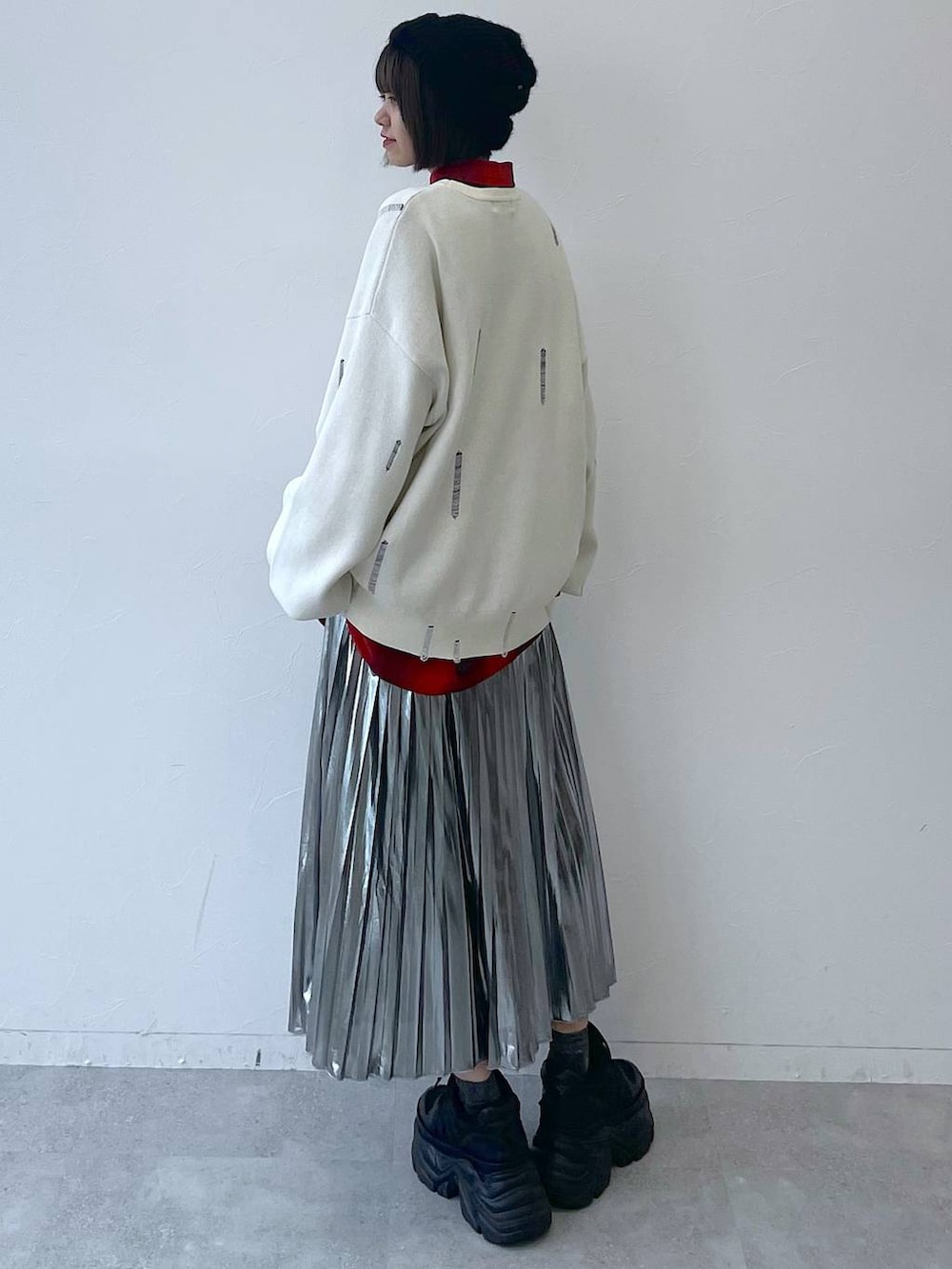 ブラック系のスニーカー、グレー系のスカート、ホワイト系のニット/セーターを着用したレディースの秋コーディネートの7枚目の写真