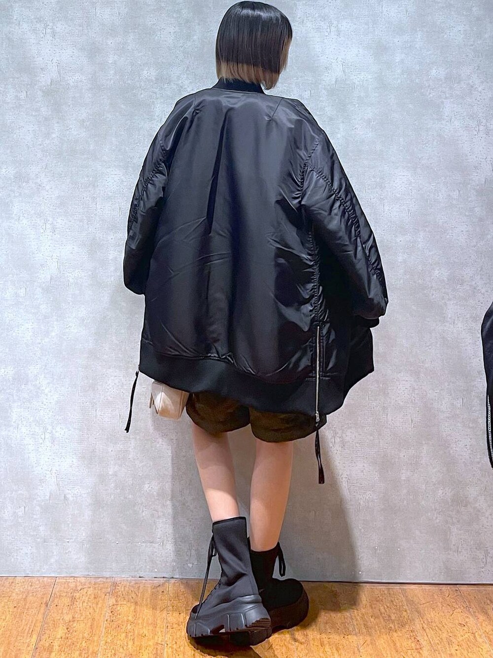 グリーン系のカーゴパンツ、ブラック系のMA-1、ブラック系のニット/セーターを着用したレディースの冬コーディネートの8枚目の写真