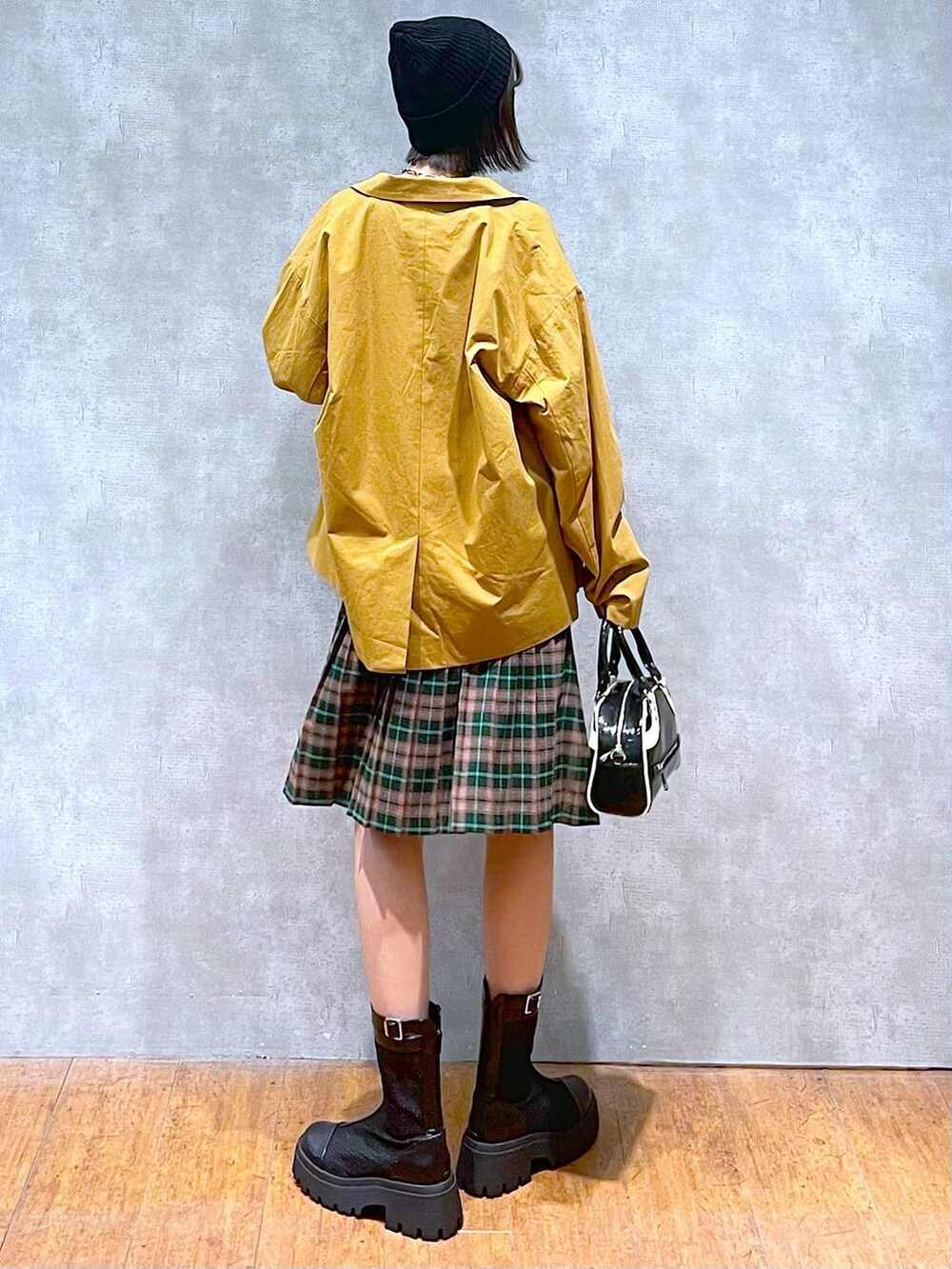 ブラック系のブーツ、ブラック系のショルダーバッグ、ブラック系のTシャツ/カットソーを着用したレディースの秋コーディネートの6枚目の写真