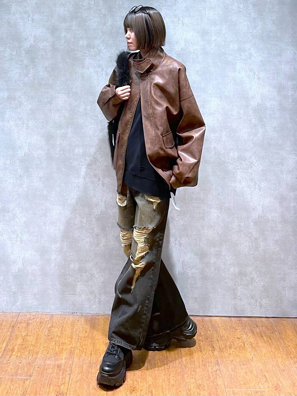 ブラウン系のブルゾン、ブラック系のブーツ、グレー系のスウェットを着用したレディースの秋コーディネートの3枚目の写真