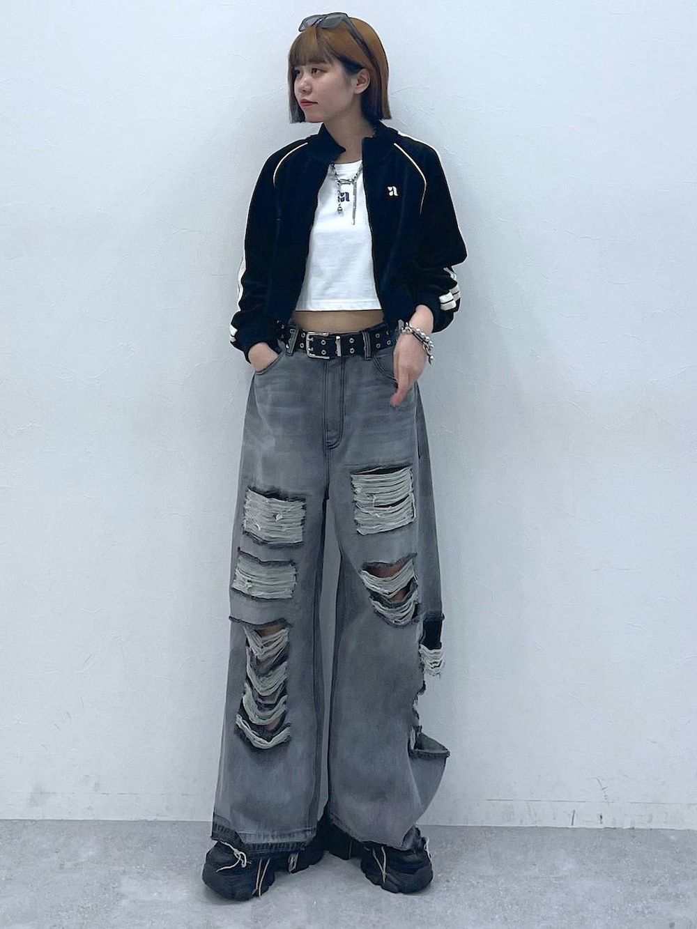 ブラック系のデニムパンツ、ブラック系のスニーカー、ホワイト系のTシャツ/カットソーを着用したレディースの夏コーディネートの4枚目の写真