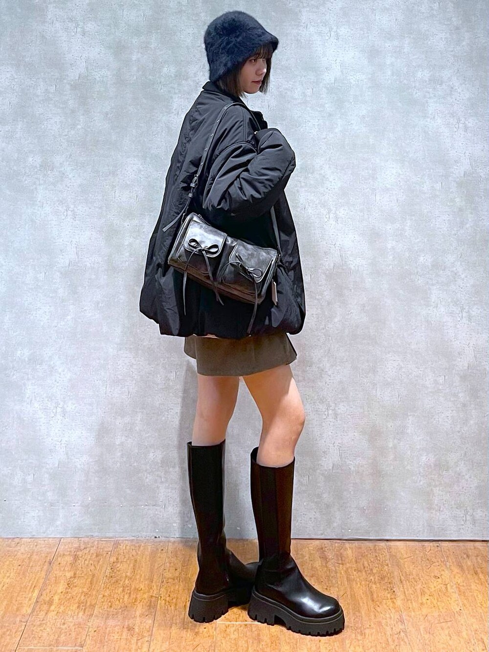 ブラック系のショルダーバッグ、ブラウン系のその他パンツ、ブラック系のブーツを着用したレディースの秋コーディネートの7枚目の写真