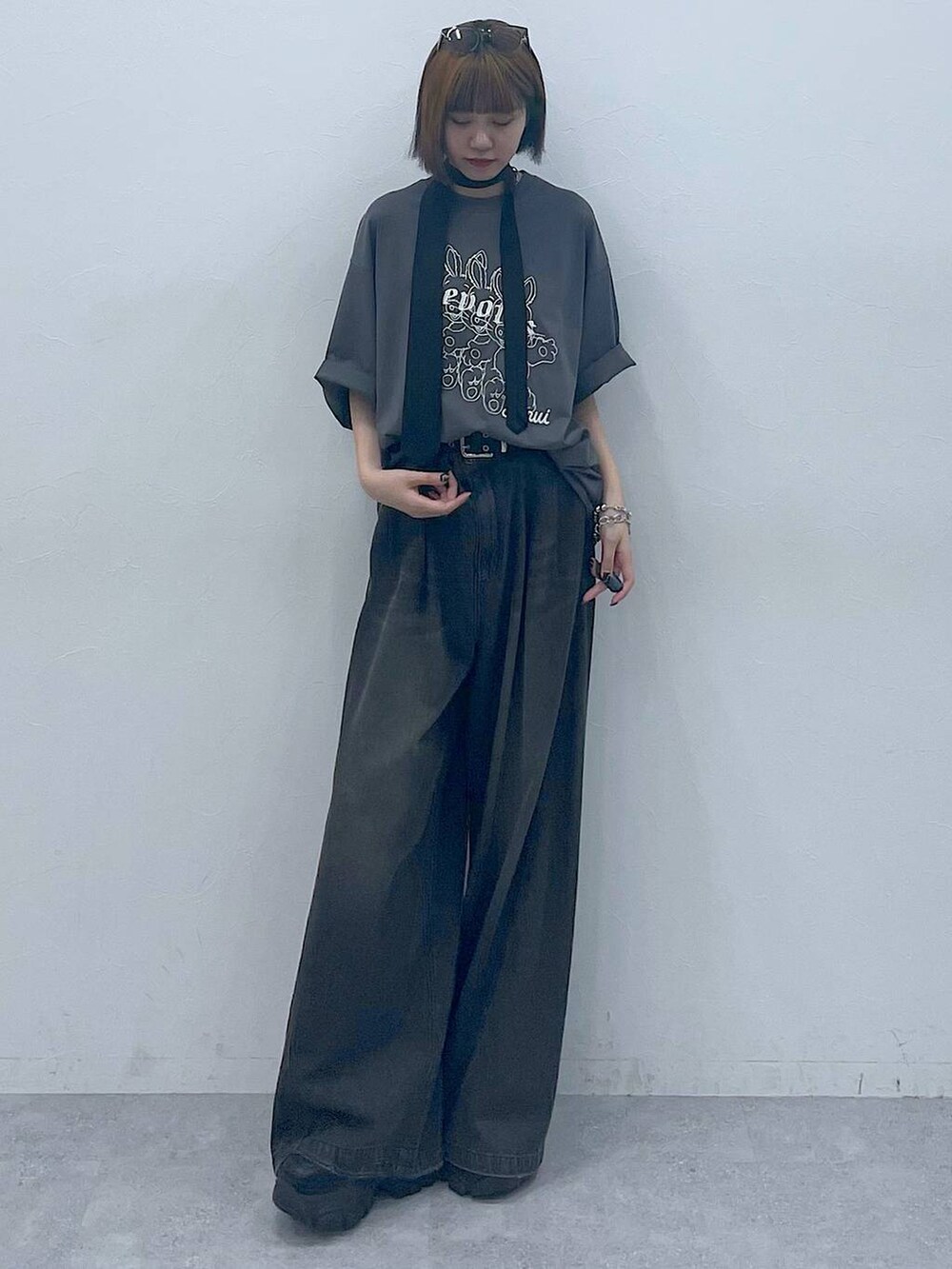 ブラック系のスニーカー、ブラック系のデニムパンツ、グレー系のTシャツ/カットソーを着用したレディースの夏コーディネートの4枚目の写真