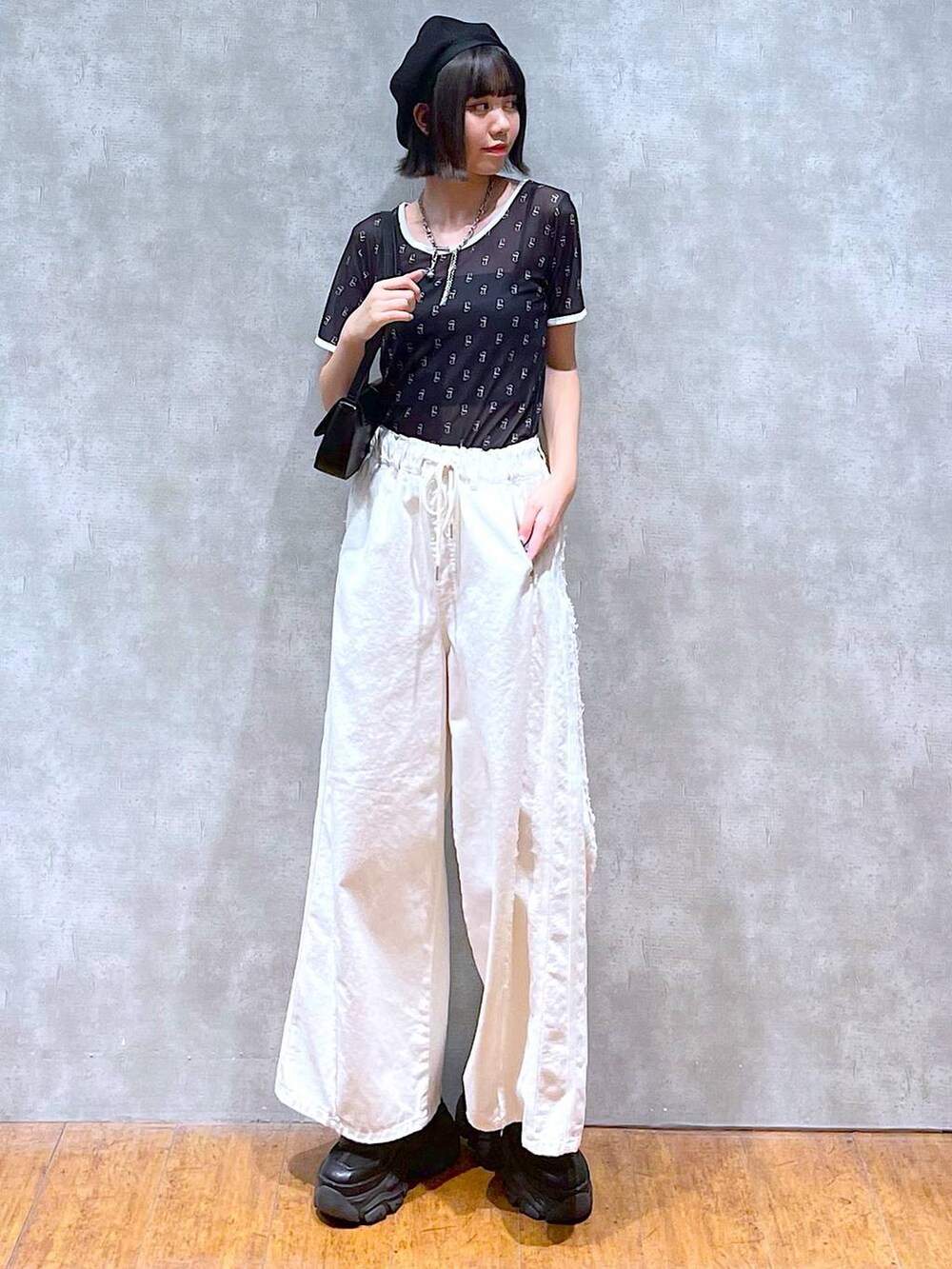 ブラック系のスニーカー、ブラック系のキャミソール、ホワイト系のデニムパンツを着用したレディースの夏コーディネートの5枚目の写真