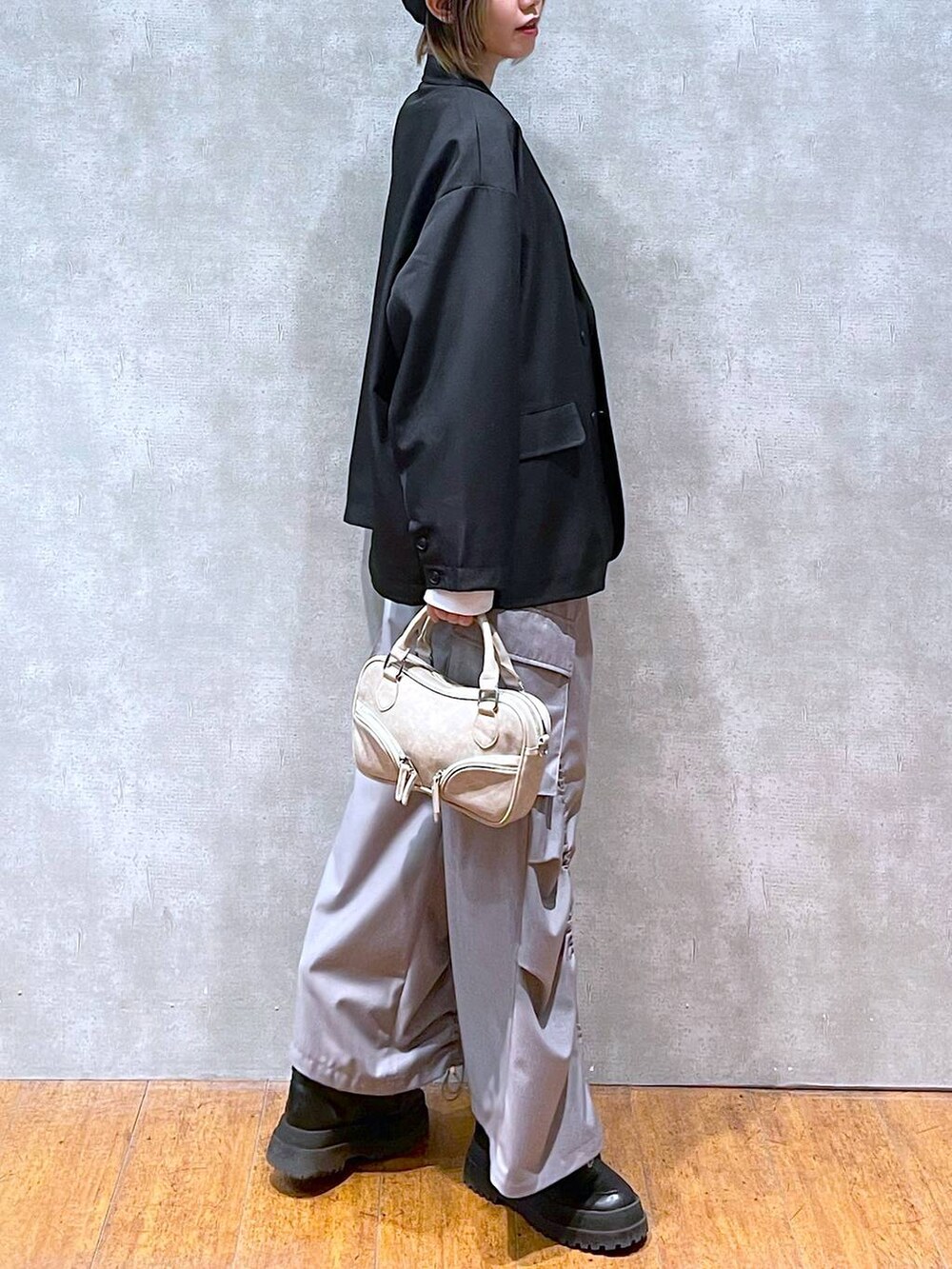 ブラック系のテーラードジャケット、ホワイト系のTシャツ/カットソー、ブラック系のブーツを着用したレディースの冬コーディネートの7枚目の写真