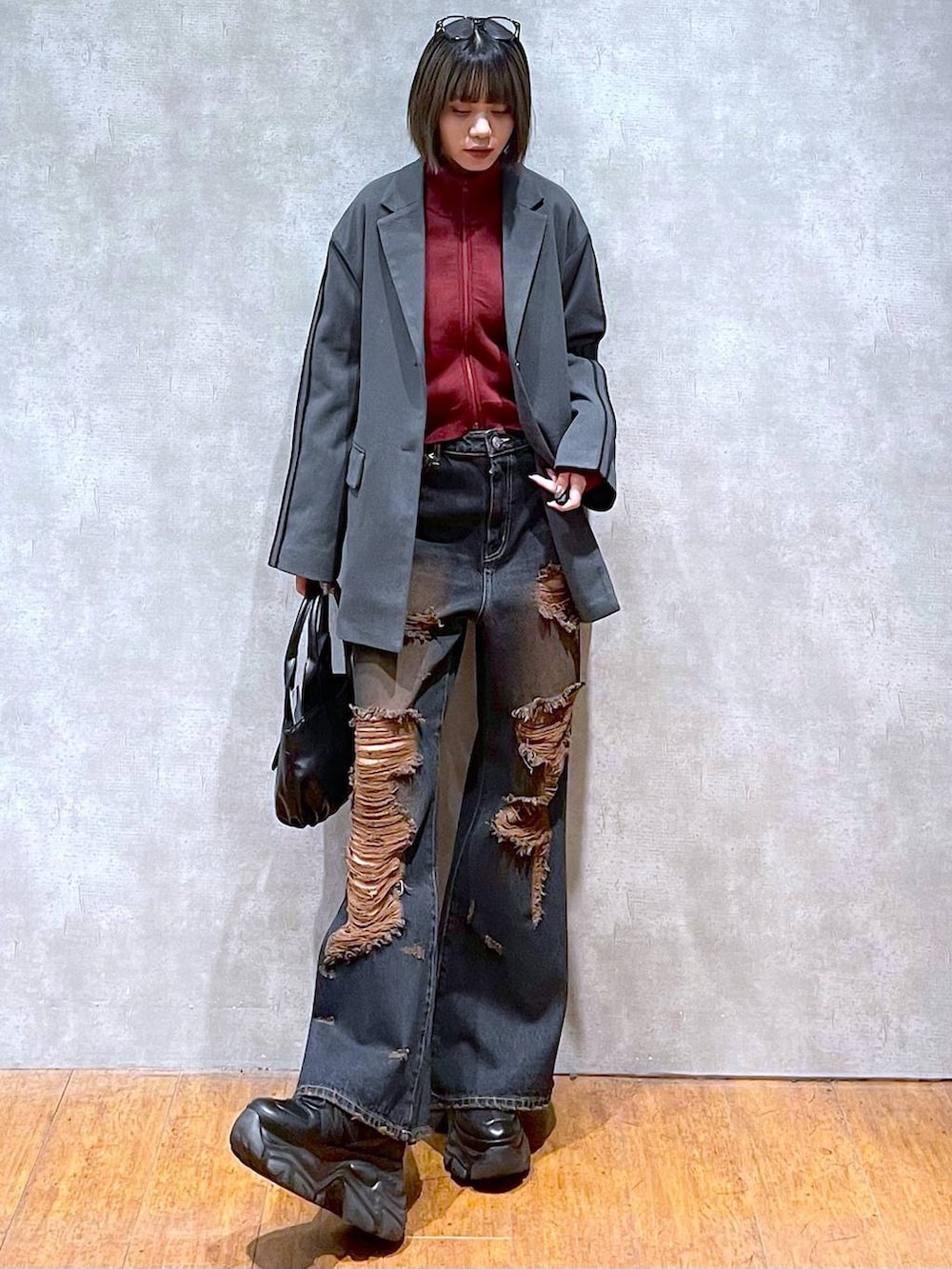 ブラック系のスニーカー、レッド系のニット/セーター、ブラック系のハンドバッグを着用したレディースの秋コーディネートの9枚目の写真