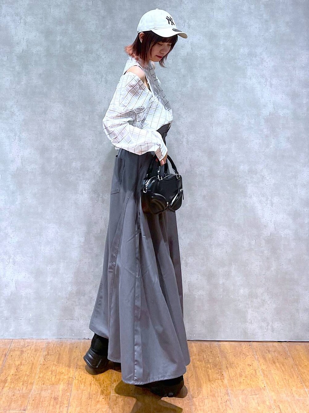 ホワイト系のシャツ/ブラウス、ブラック系のキャミソール、グレー系のジャンパースカートを着用したレディースの春コーディネートの4枚目の写真