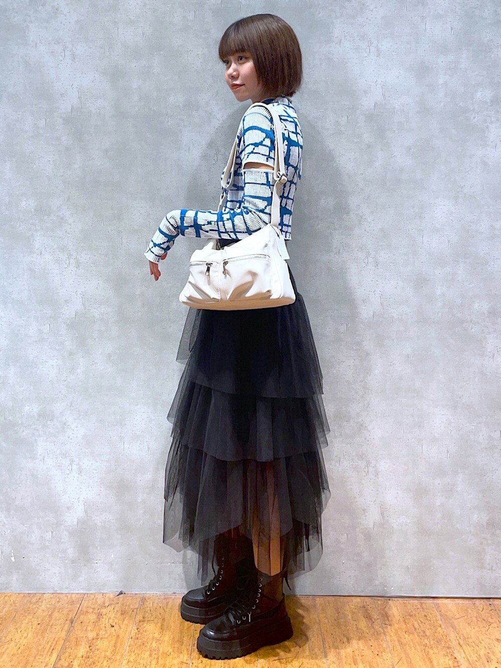 ホワイト系のニット/セーター、ホワイト系のショルダーバッグ、ブラック系のスカートを着用したレディースの秋コーディネートの2枚目の写真