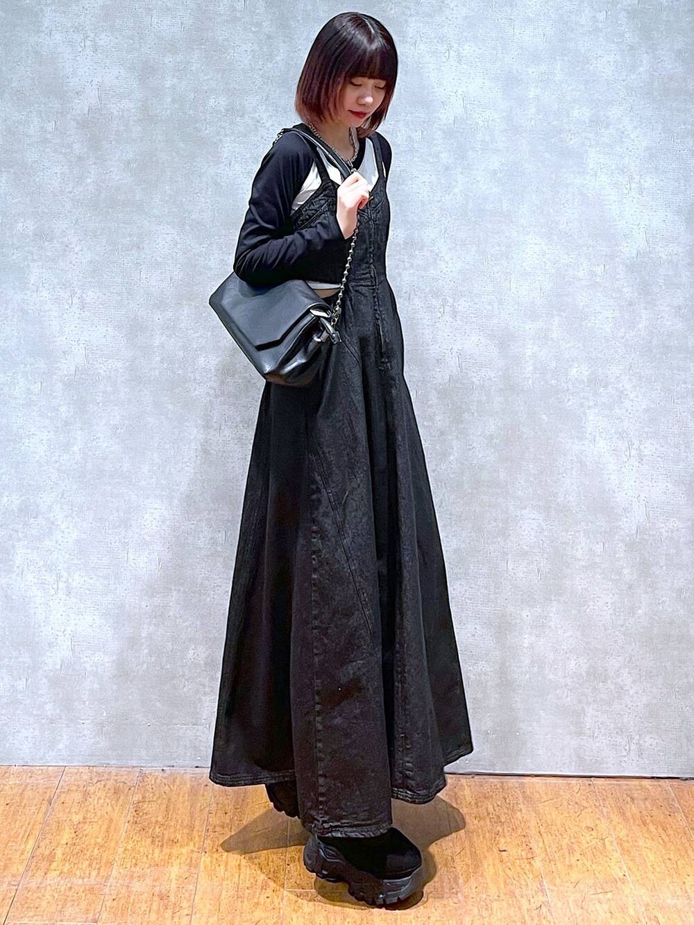 ブラック系のショルダーバッグ、ホワイト系のTシャツ/カットソー、ブラック系のワンピースを着用したレディースの春コーディネートの3枚目の写真