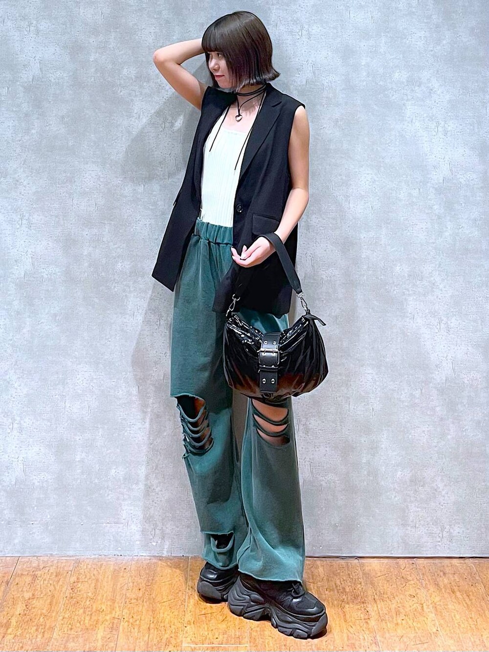 ホワイト系のタンクトップ、ブラック系のスニーカー、ブラック系のショルダーバッグを着用したレディースの夏コーディネートの2枚目の写真