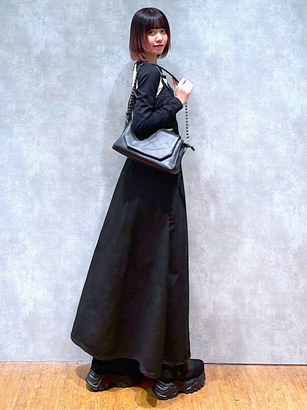 ブラック系のショルダーバッグ、ホワイト系のTシャツ/カットソー、ブラック系のワンピースを着用したレディースの春コーディネートの4枚目の写真