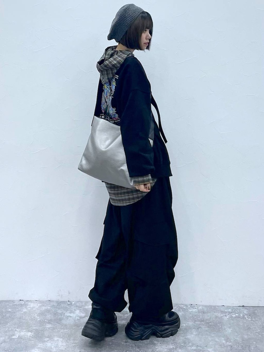 ブラック系のスニーカー、ブラック系のスウェット、シルバー系のトートバッグを着用したレディースの秋コーディネートの6枚目の写真