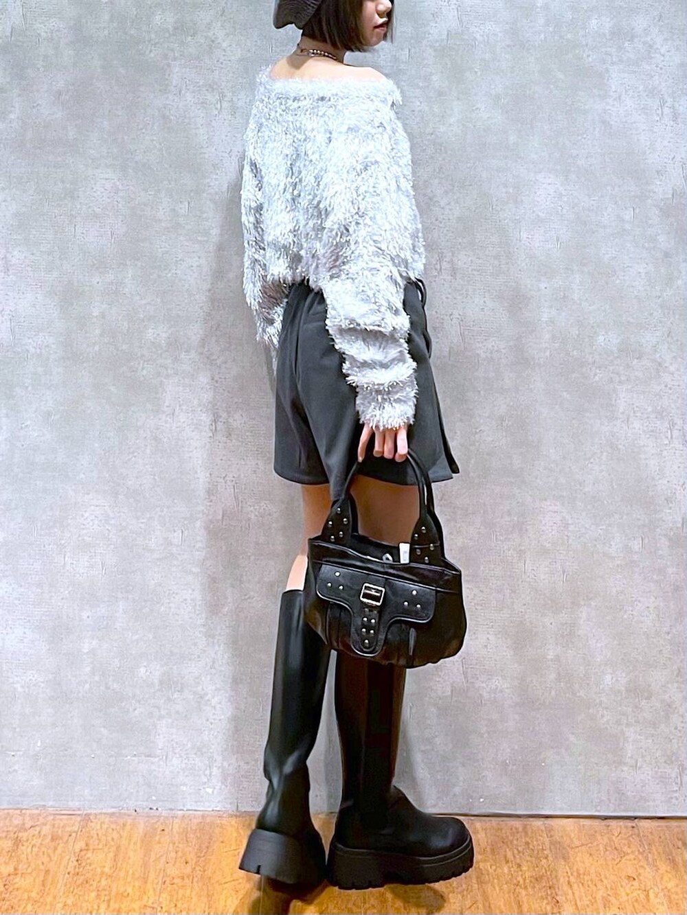 グレー系のその他パンツ、ブラック系のハンドバッグ、ブラック系のブーツを着用したレディースの秋コーディネートの4枚目の写真