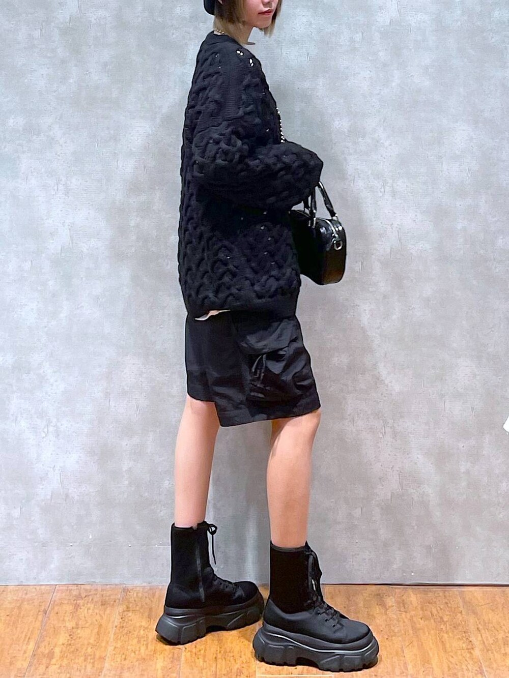 ホワイト系のTシャツ/カットソー、ブラック系のカーゴパンツ、ブラック系のカーディガン/ボレロを着用したレディースの冬コーディネートの6枚目の写真