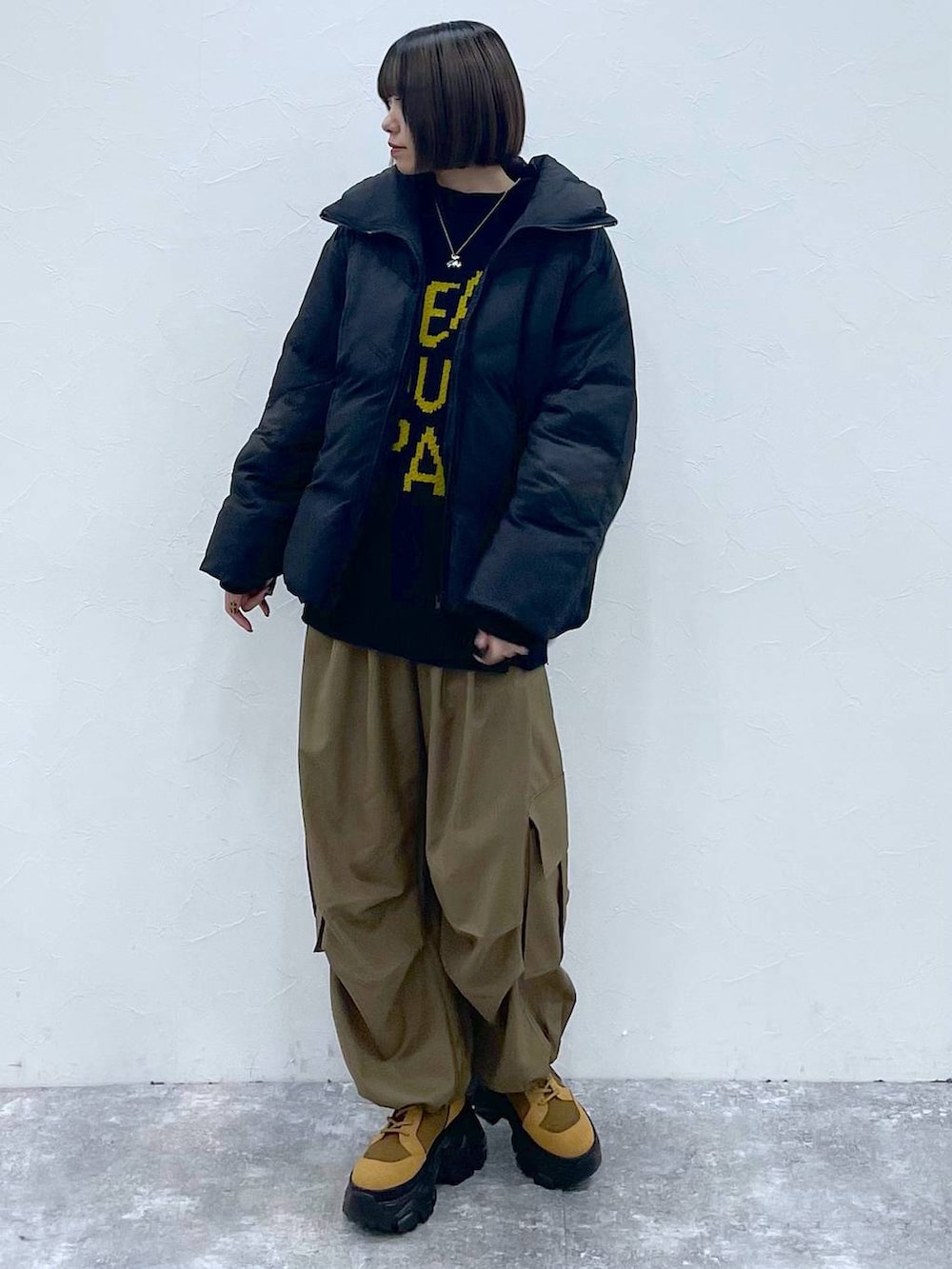 ブラウン系のブーツ、ベージュ系のカーゴパンツ、ブラック系のブルゾンを着用したレディースの秋コーディネートの9枚目の写真