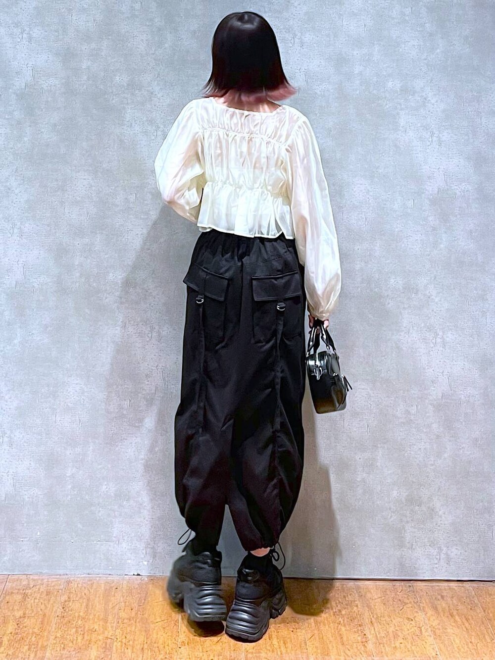 ブラック系のスニーカー、ベージュ系のシャツ/ブラウス、ホワイト系のキャミソールを着用したレディースの春コーディネートの4枚目の写真