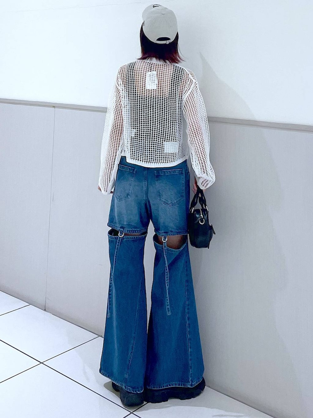 ホワイト系のカーディガン/ボレロ、ブラック系のタンクトップ、ブルー系のデニムパンツを着用したレディースの春コーディネートの7枚目の写真