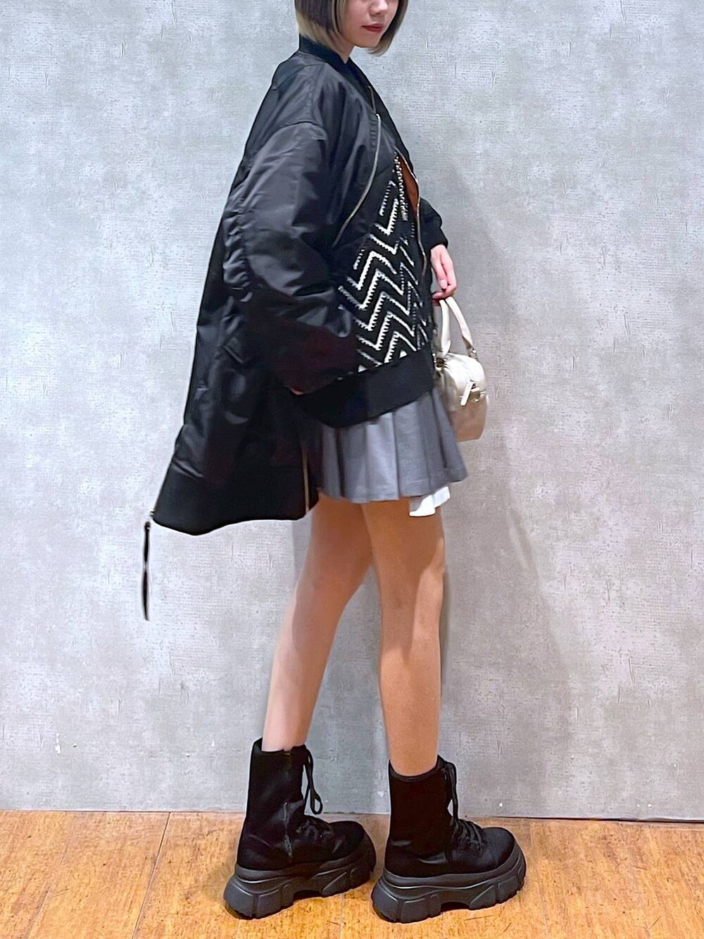 ブラック系のMA-1、ブラック系のブーツ、ブラック系のニット/セーターを着用したレディースの冬コーディネートの4枚目の写真